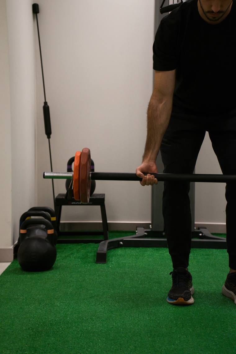 Trabajo de fuerza con barra en la sala de ejercicio terapéutico